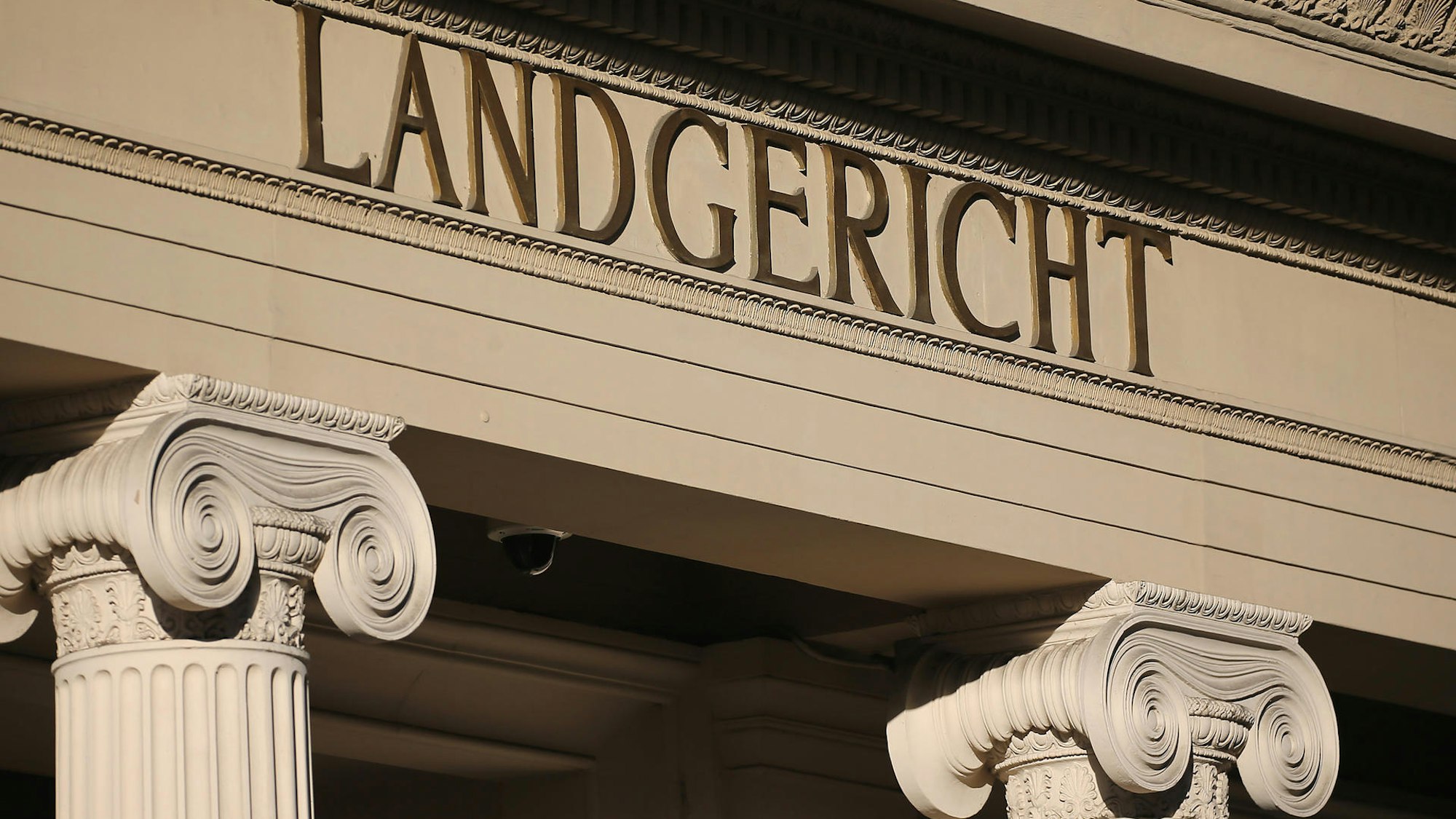 Auf einem auf verschnörkelten Säulen getragenen Mauerstück steht das Wort Landgericht.