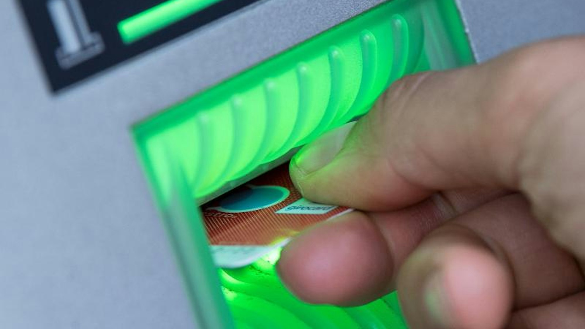 Ein Mann steckt eine Bankkarte in einen Geldautomaten.
