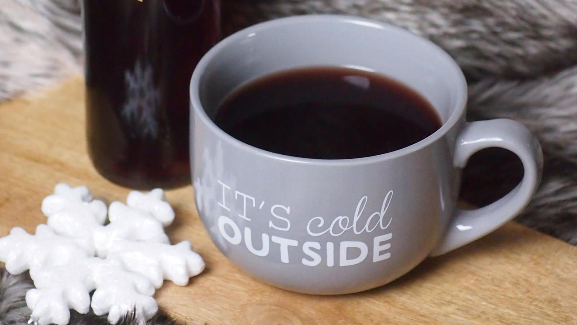 Punsch in einer grauen Tasse mit Schriftzug „It's cold outside“