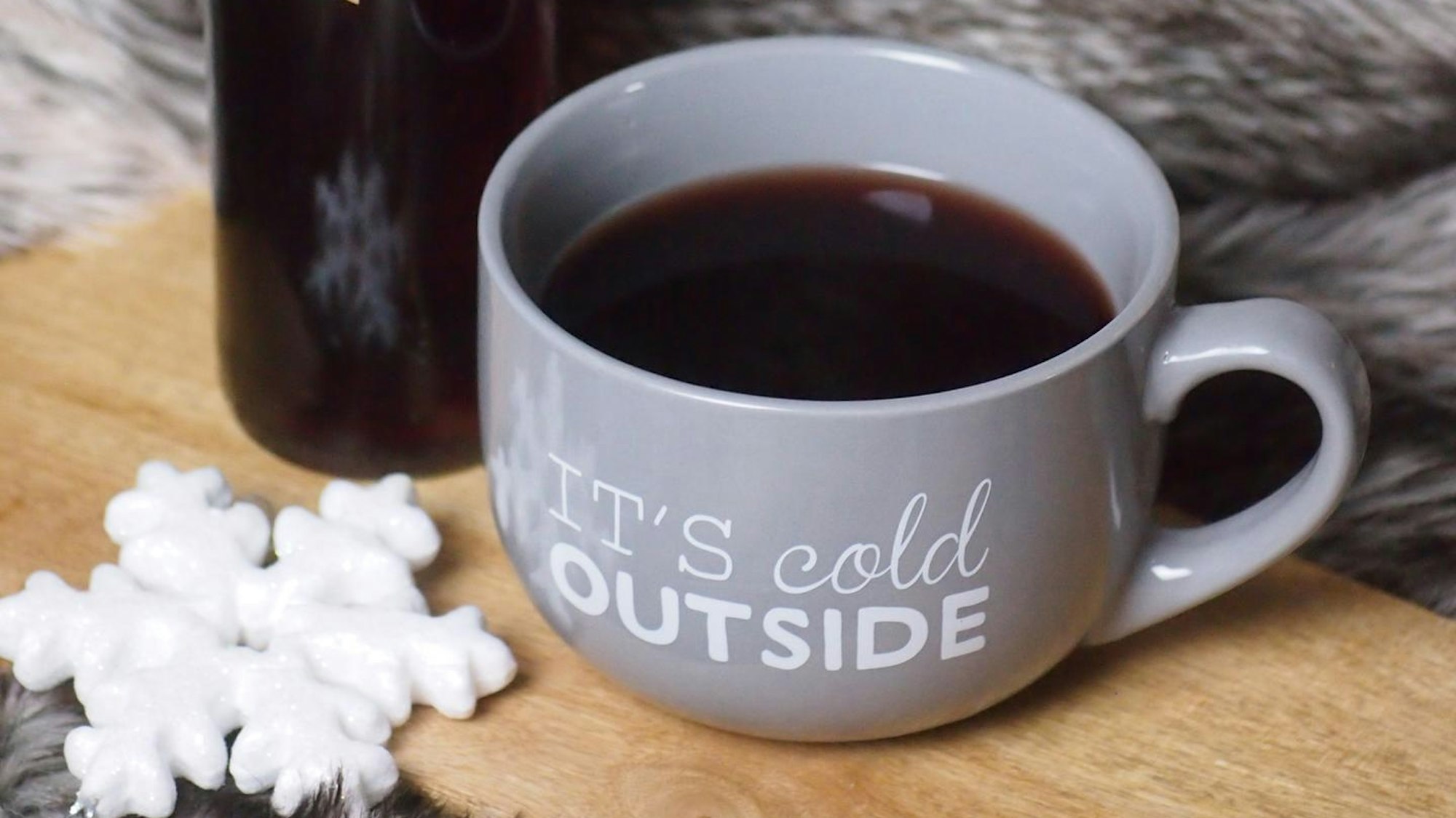 Punsch in einer grauen Tasse mit Schriftzug „It's cold outside“