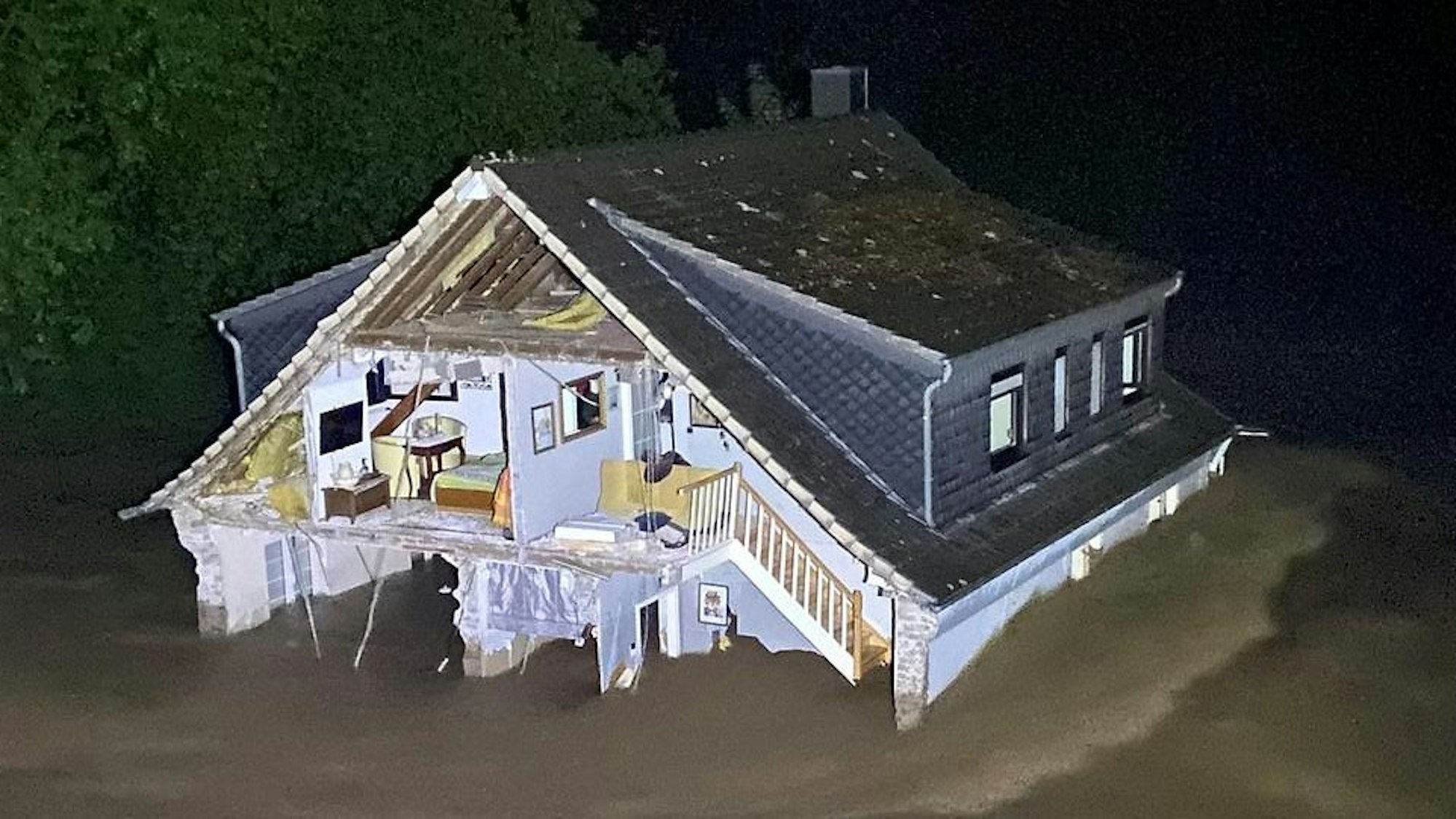Die eingestürzte Giebelwand gibt den Blick in das Innere des Hauses frei.