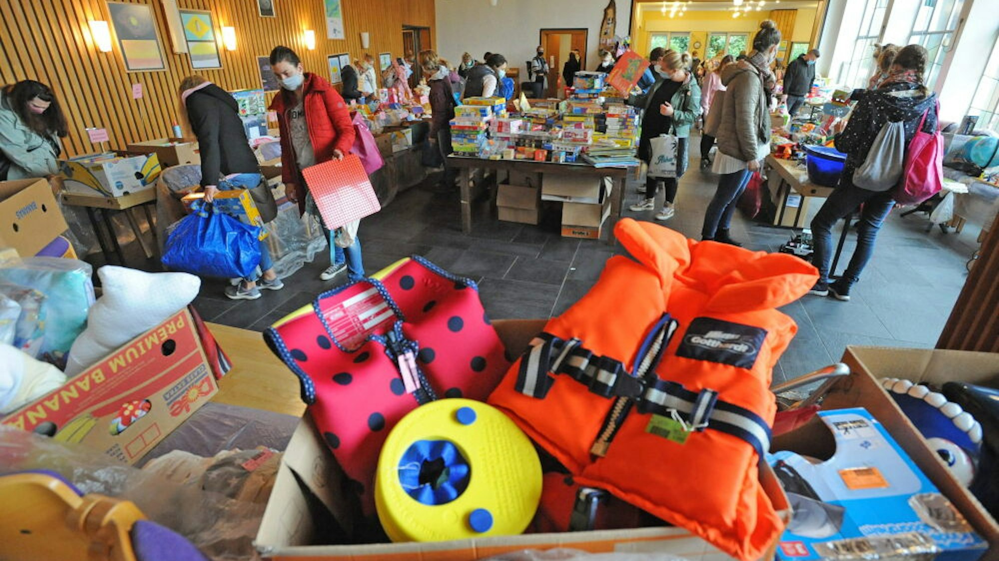 Blick in eine Veranstaltungshalle mit Kindersachen auf den Tischen.