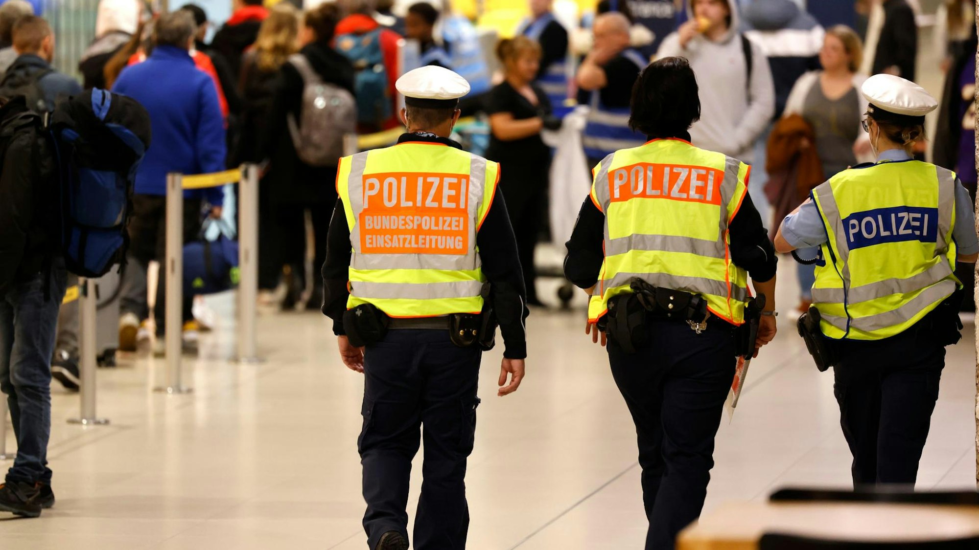 Bundepolizisten gehen durch die Flughafenhalle.