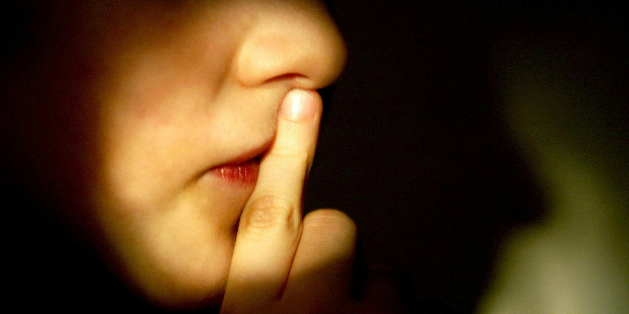 Aphasie_Symbolbild_Junge_hält_sich_Finger_vor_den_Mund