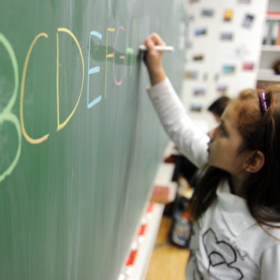 Kind schreibt an Schultafel