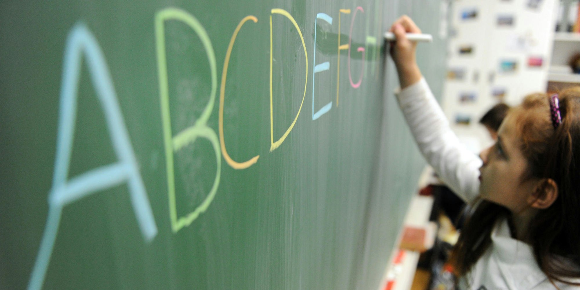 Kind schreibt an Schultafel