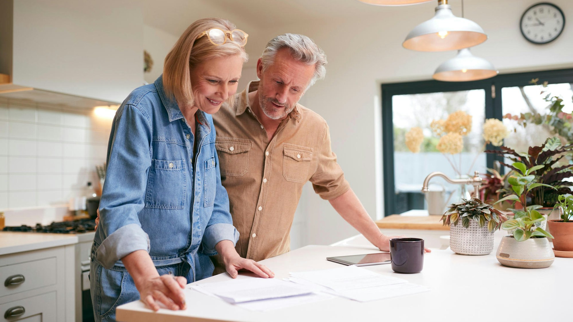 Eine Frau und ein Mann blicken auf Papiere