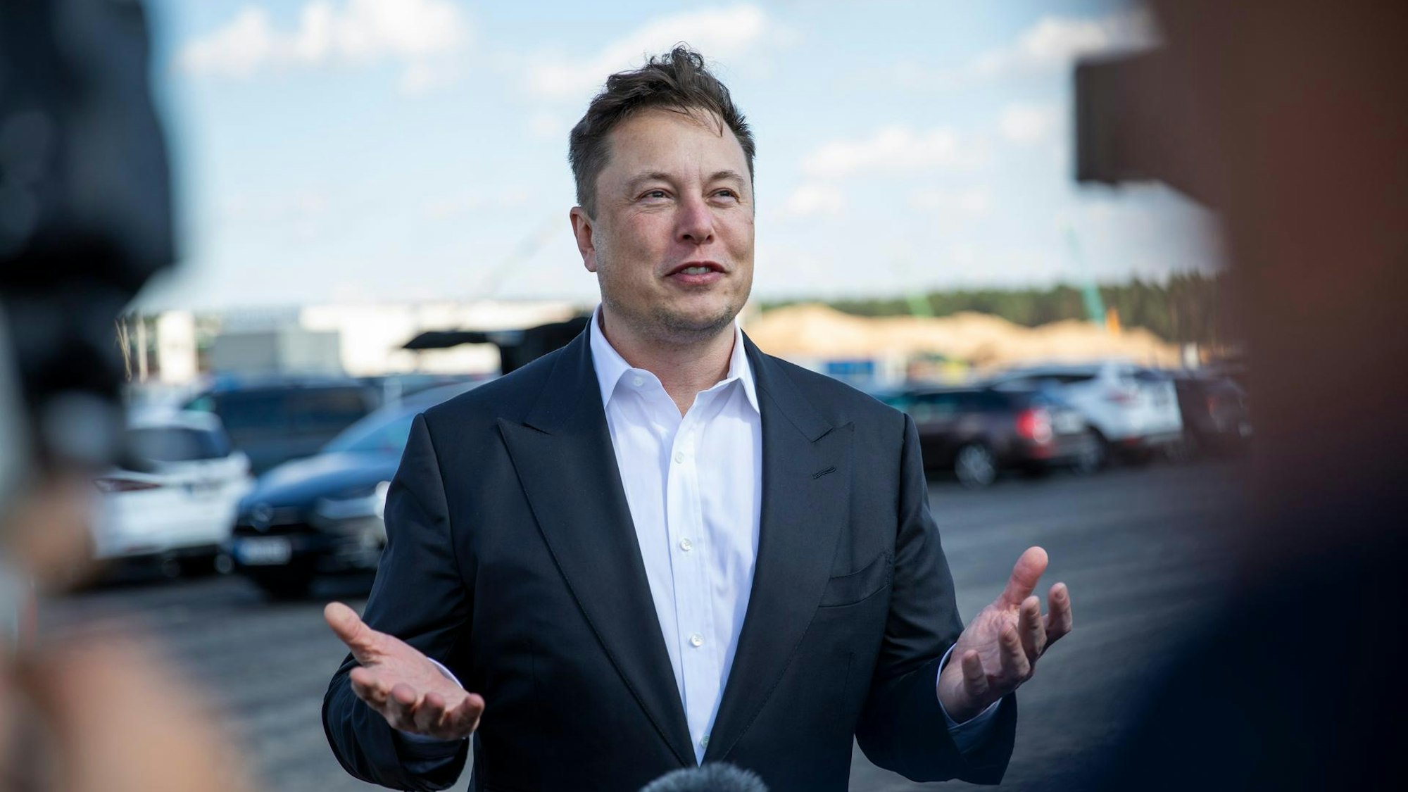 Elon Musk gibt ein Interview auf einem Parkplatz.E