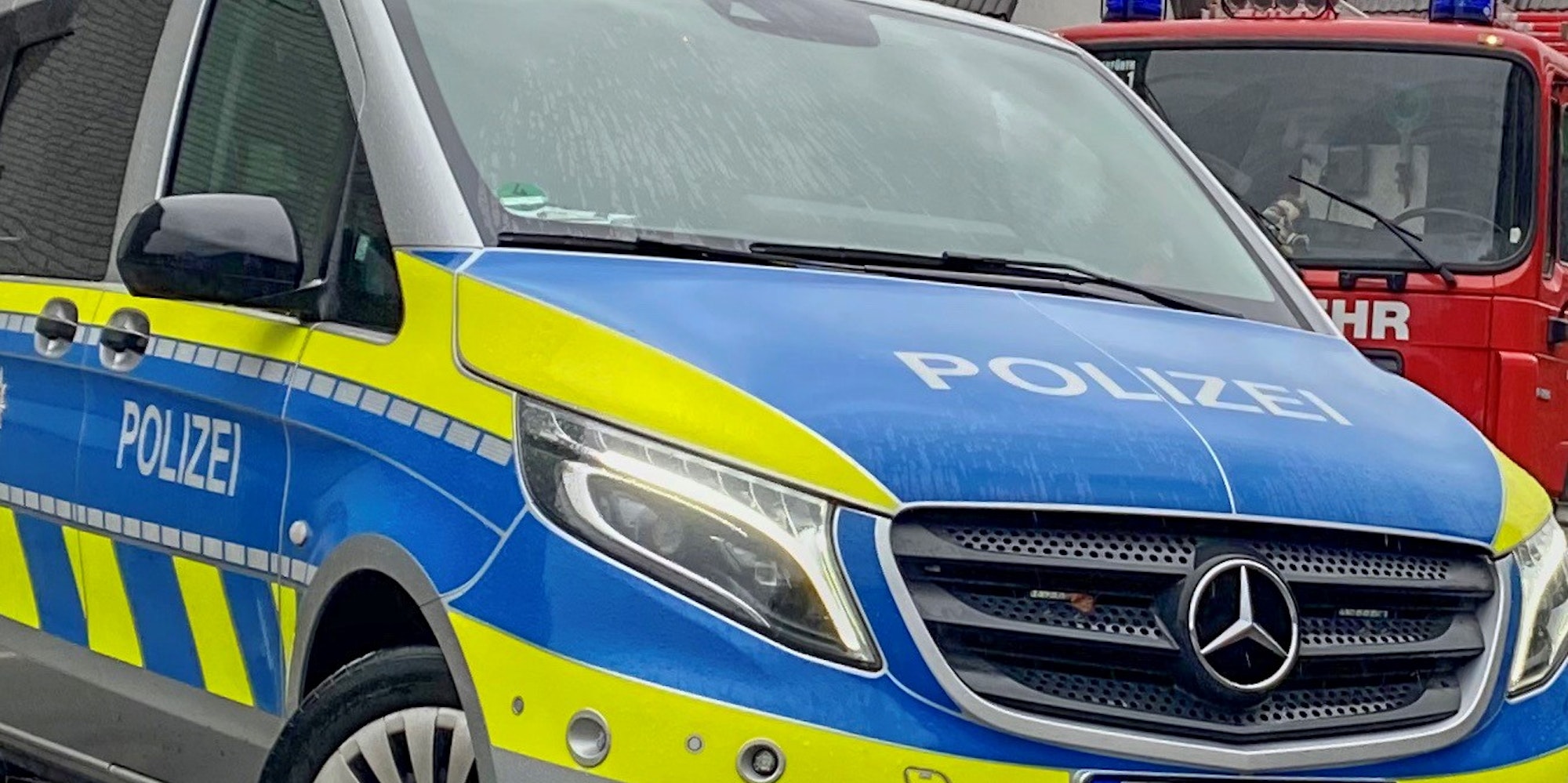 Ein Polizeiauto steht vor einem Feuerwehrauto.