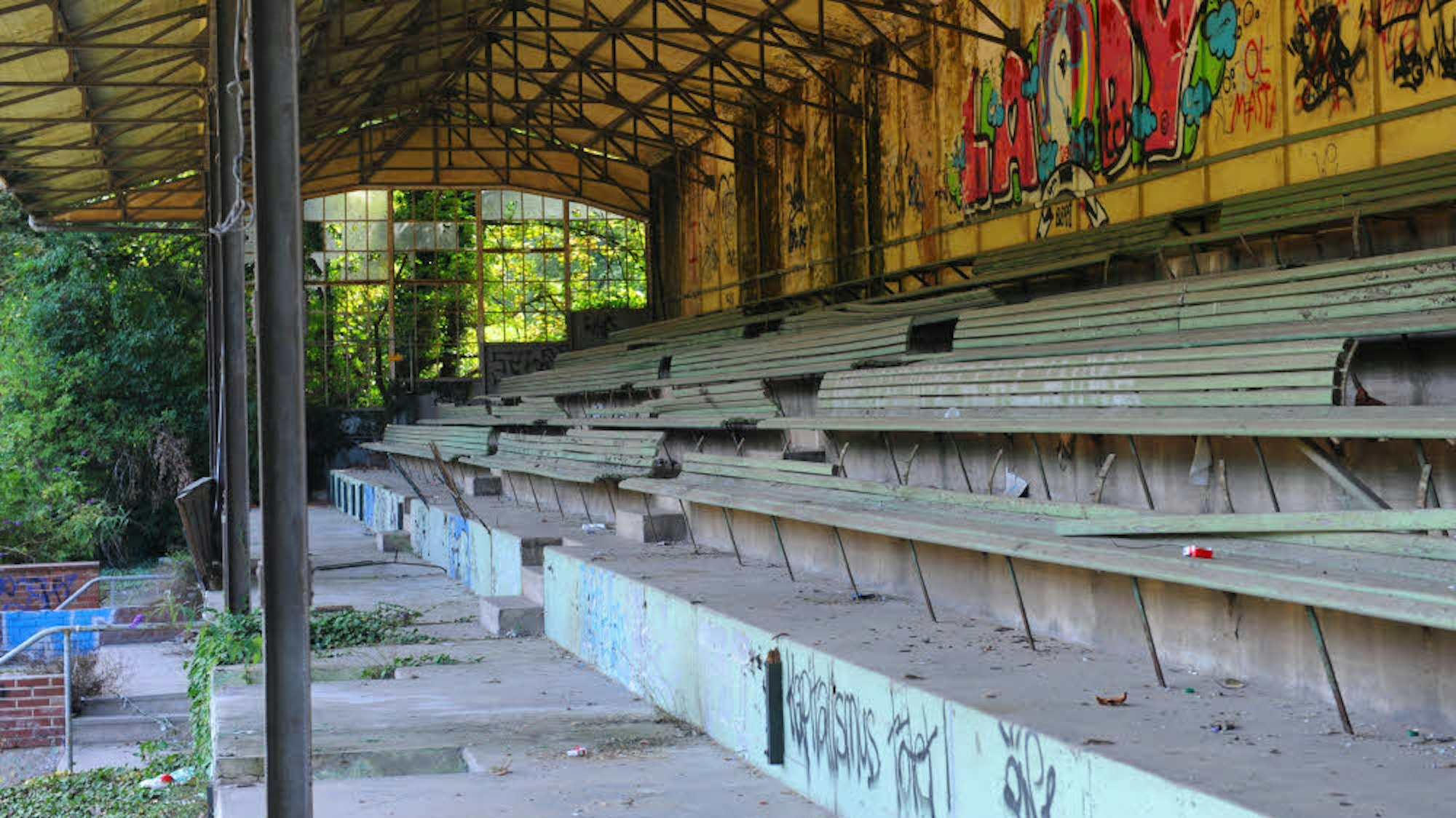 Graffiti an den Wänden und kaputte Bänke zieren die alte Tribüne.