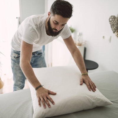 Mann macht sein Bett imago