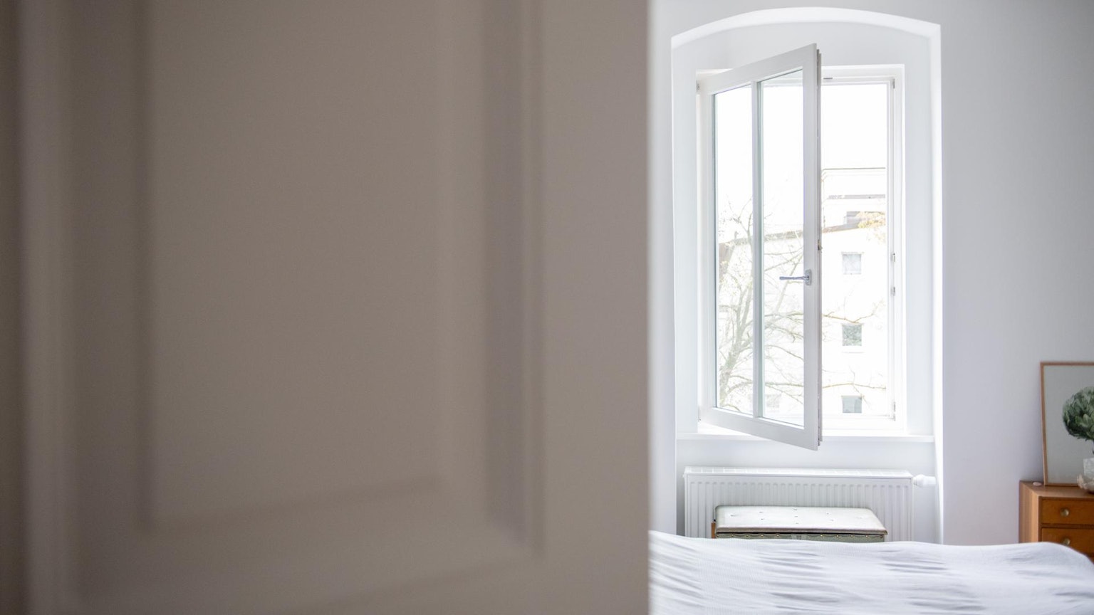 Das Fenster in einem Schlafzimmer steht weit offen.