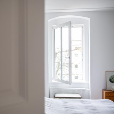 Das Fenster in einem Schlafzimmer steht weit offen.