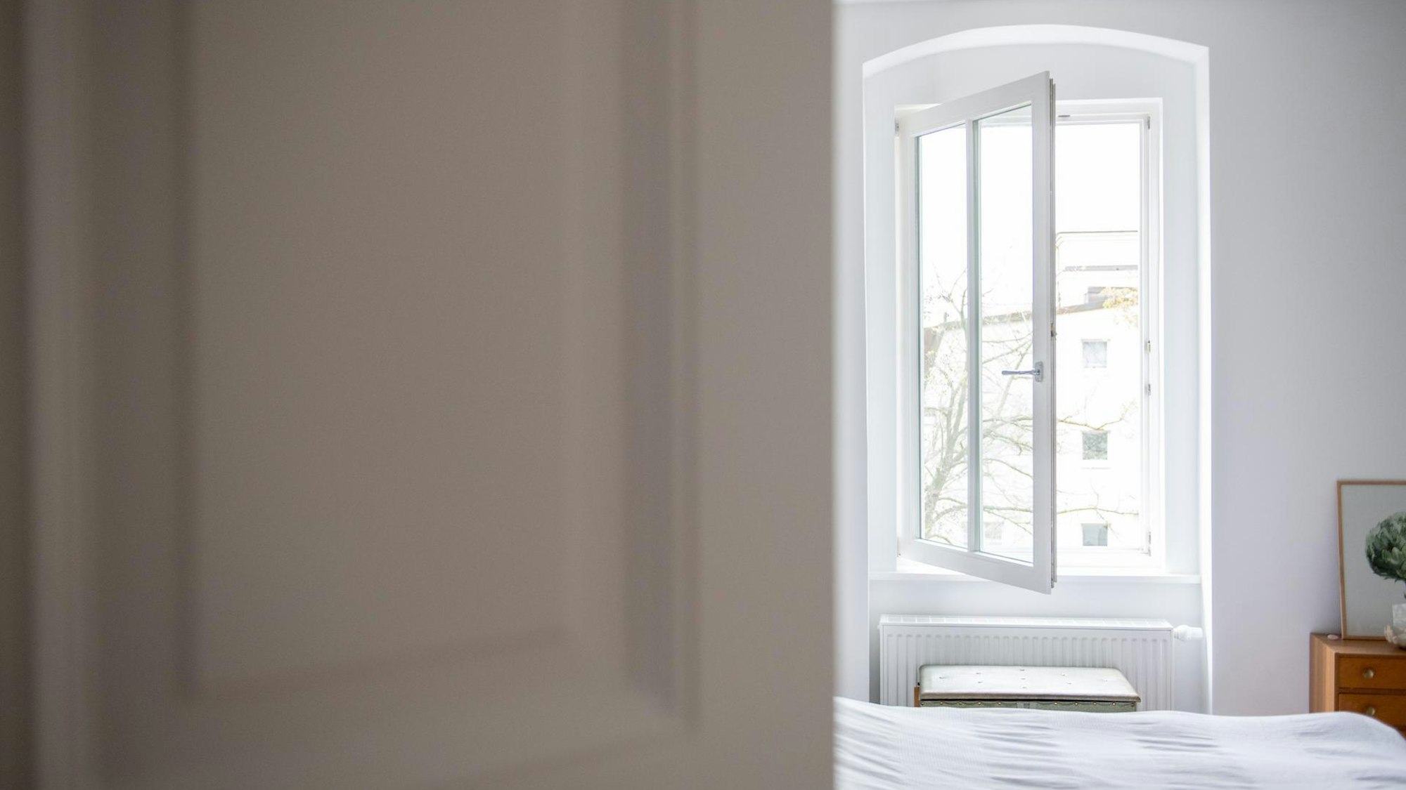 Das Fenster in einem Schlafzimmer steht weit offen.