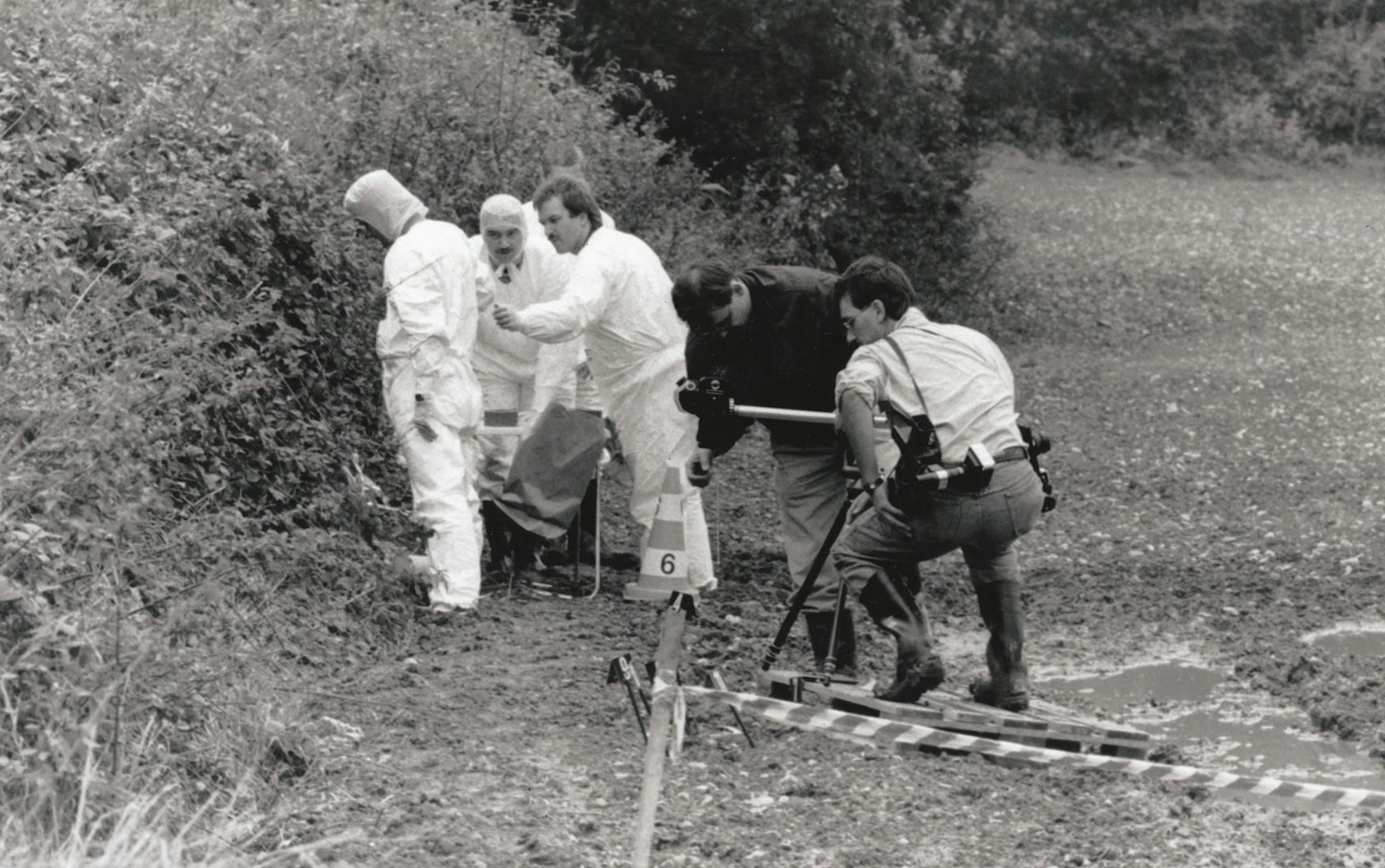 Ermittler der Kölner Polizei sichern Spuren in dem Gebüsch in Poll, wo 1991 die Leiche von Seckin Caglar gefunden wurde.