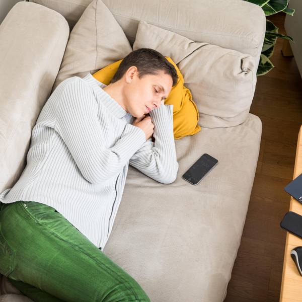 Eine Frau schläft auf dem Sofa.