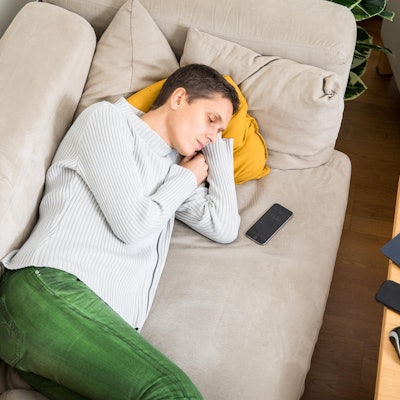 Eine Frau schläft auf dem Sofa.