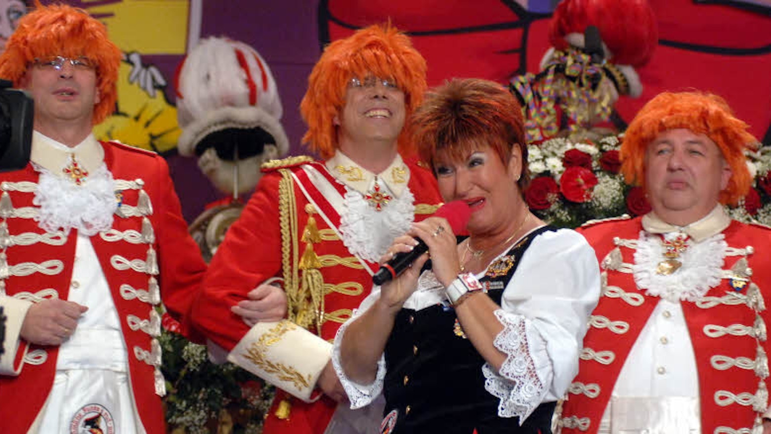 Marita Köllner steht mit den Roten Funken au der Bühne