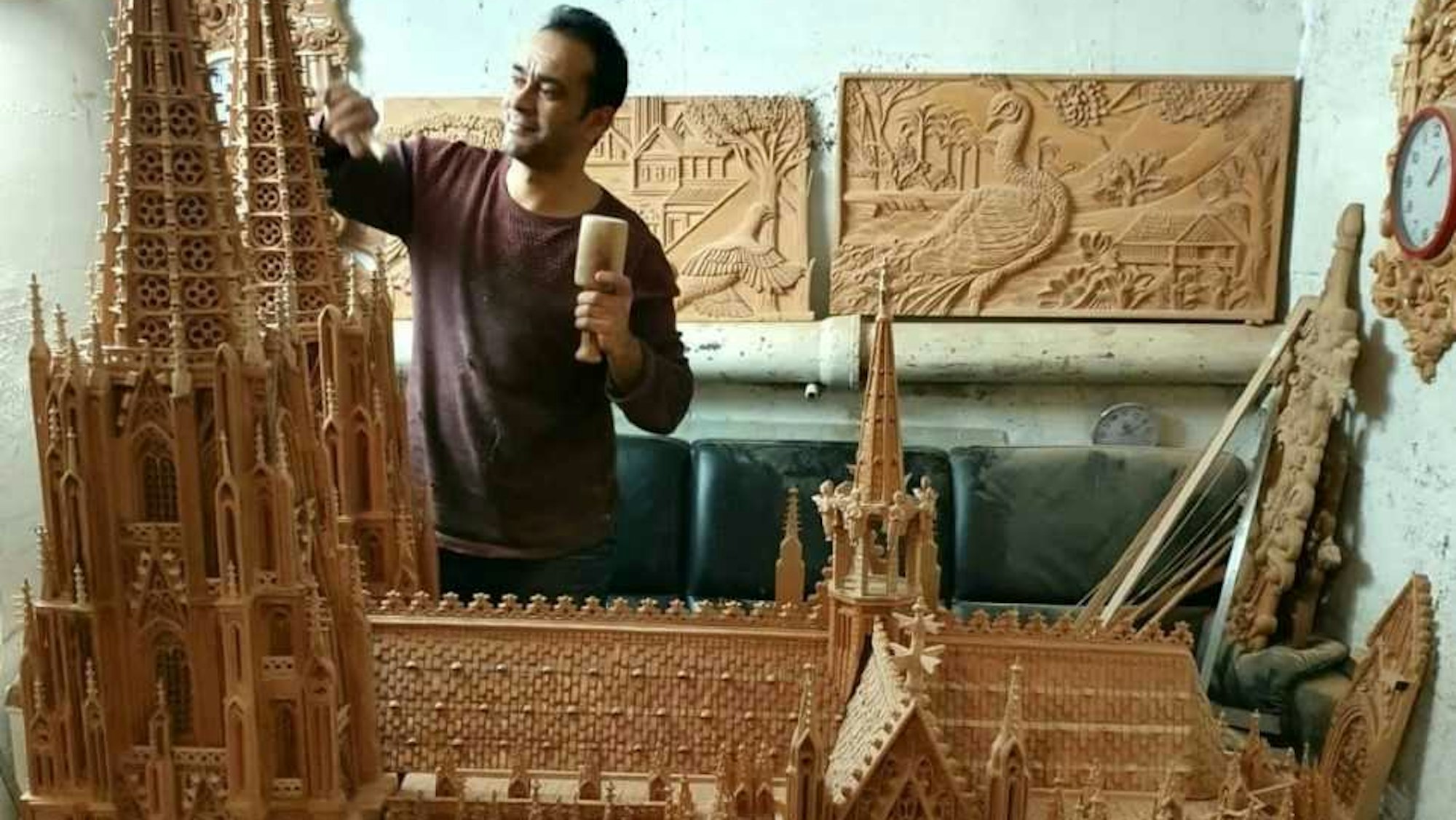 Ein großes Holzmodell des Kölner Doms. Hinter dem Modell steht der Künstler in einem roten Pullover.