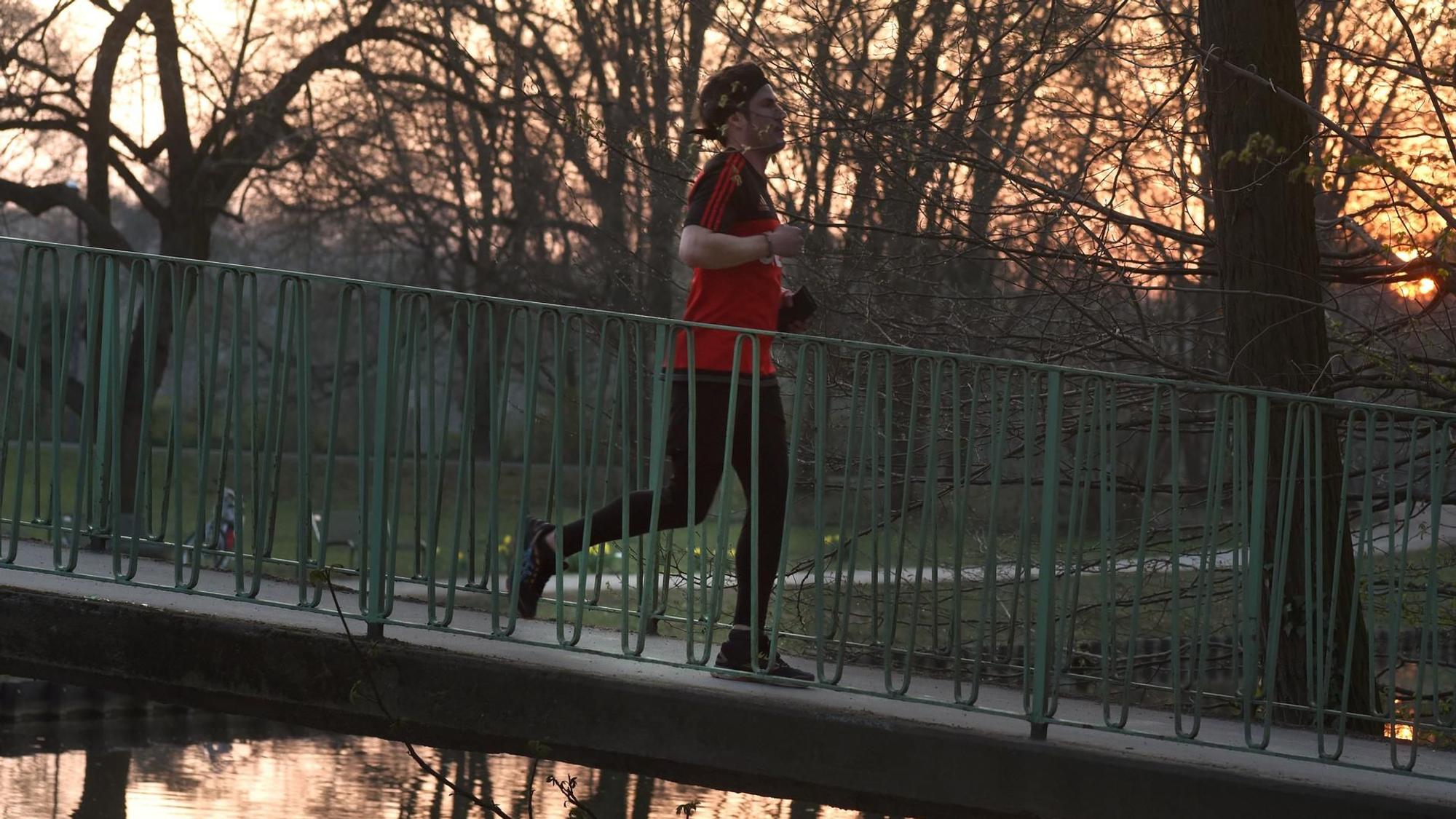 Jogger läuft über eine kleine Brücke in einem Park