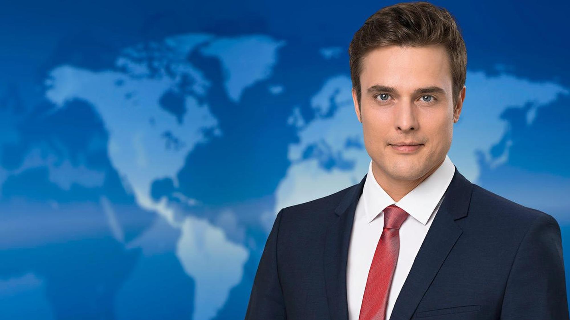 Constantin Schreiber vor der Tagesschau-Wand.