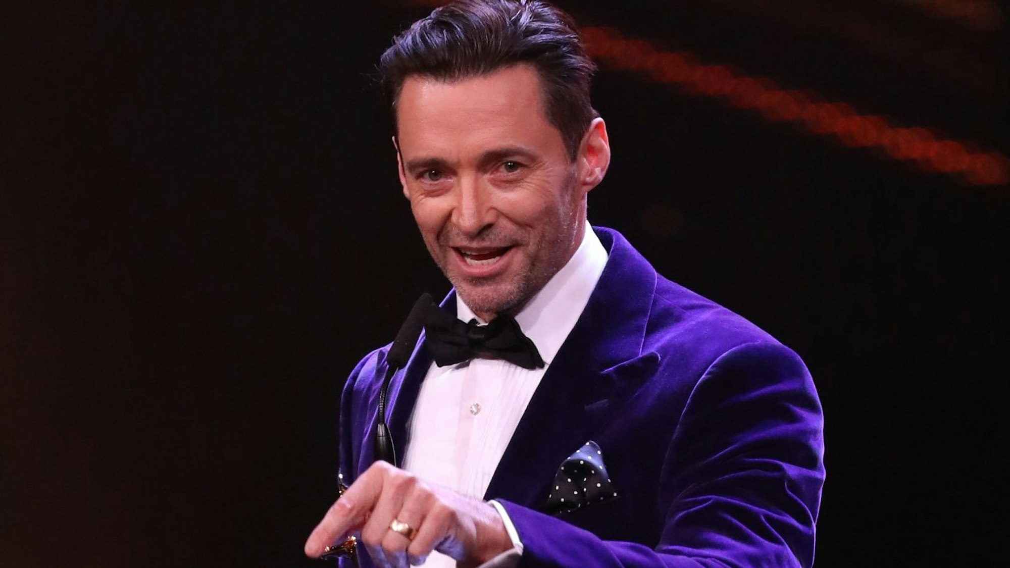 Hugh Jackman spricht und holt mit dem Finger aus.
