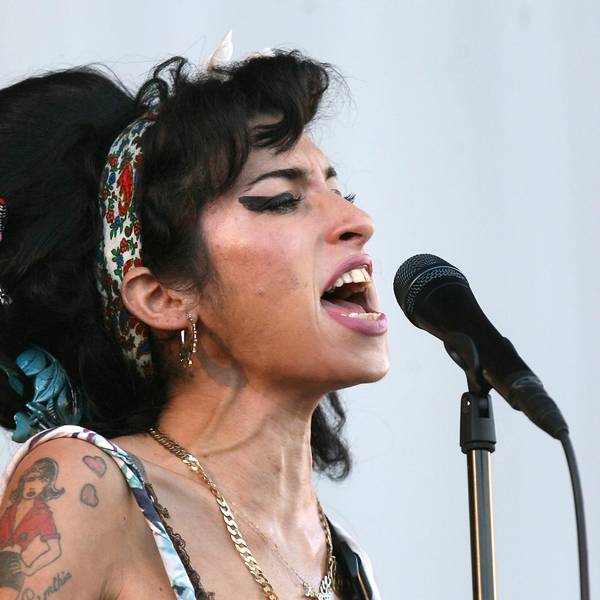 Amy Winehouse singt in einer Mikro.