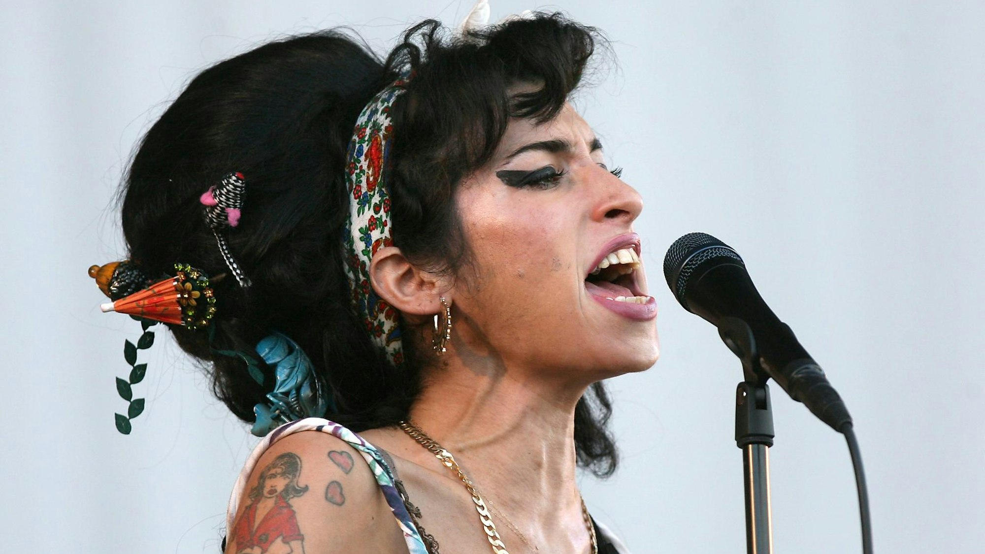 Amy Winehouse singt in einer Mikro.