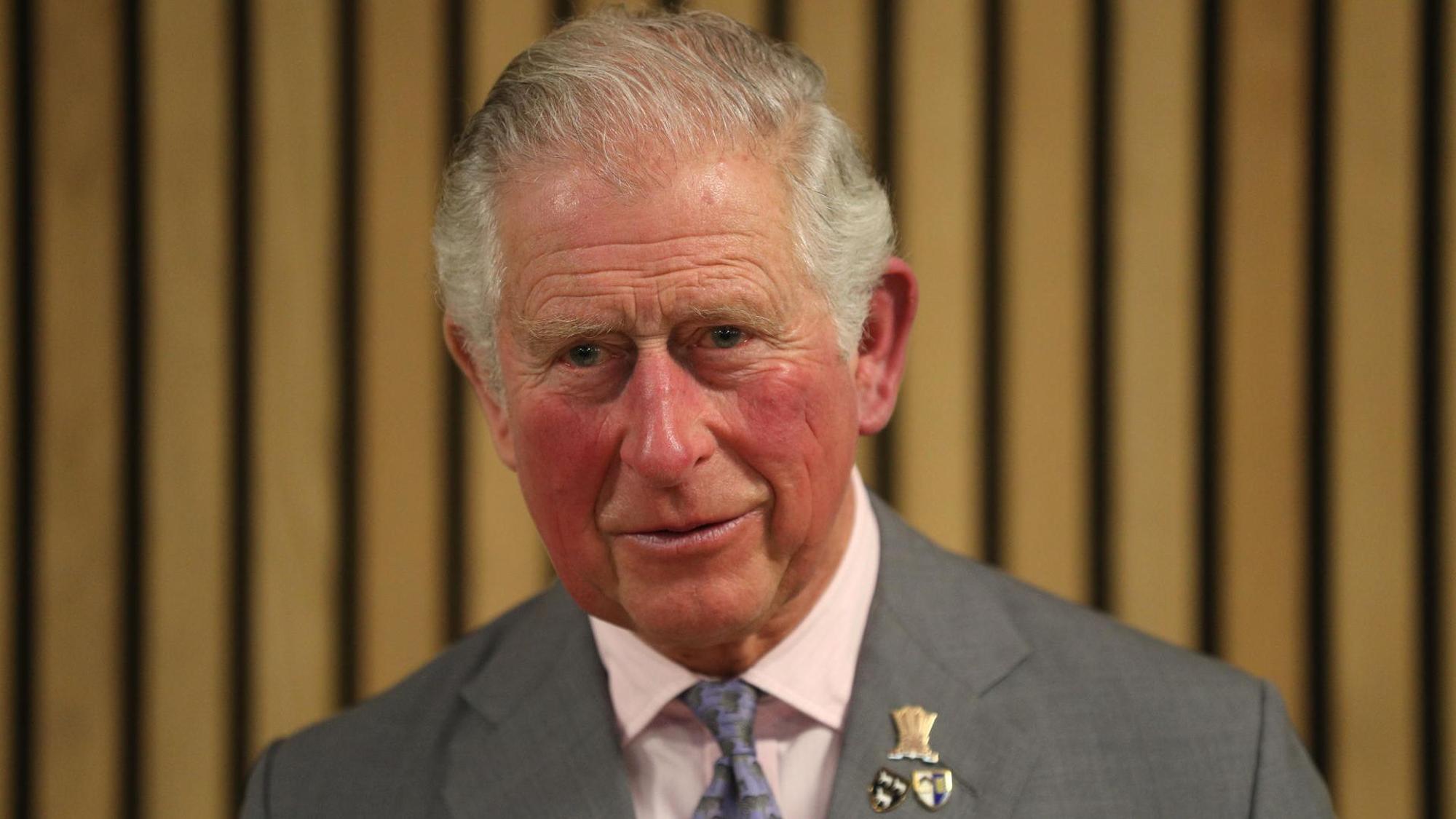 Prinz Charles mit Orden schaut zu den Reportern.
