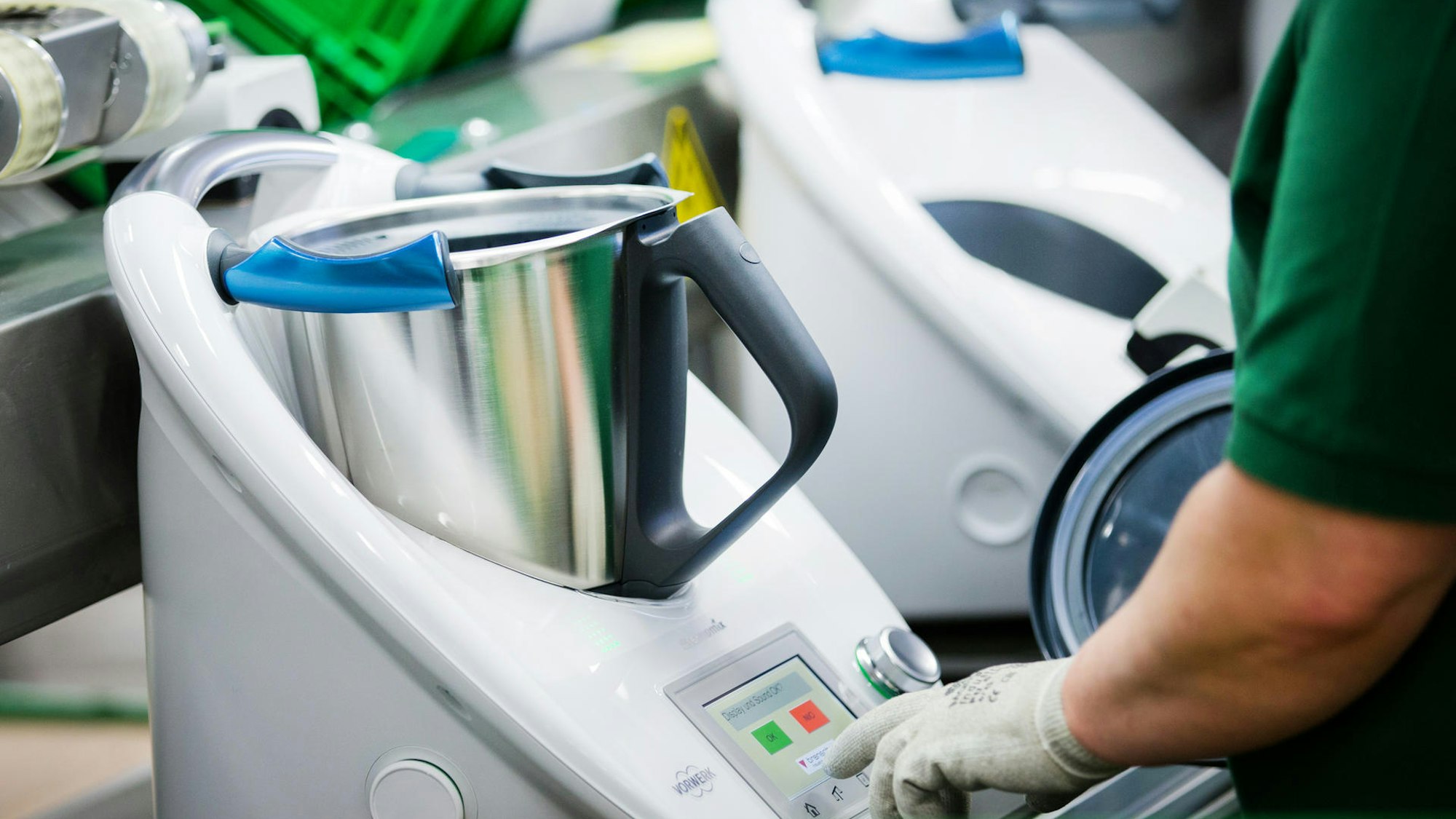 Mehrere Thermomix-Küchengeräte mit silbernen Töpfen in weißen Plastikgehäusen stehen nebeneinander.