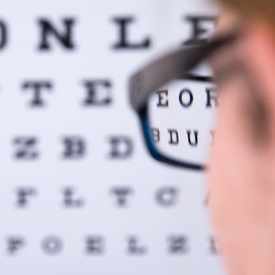 Symbolbild_Kurzsichtikeit_Mann_steht_vor_Buchstabentafel
