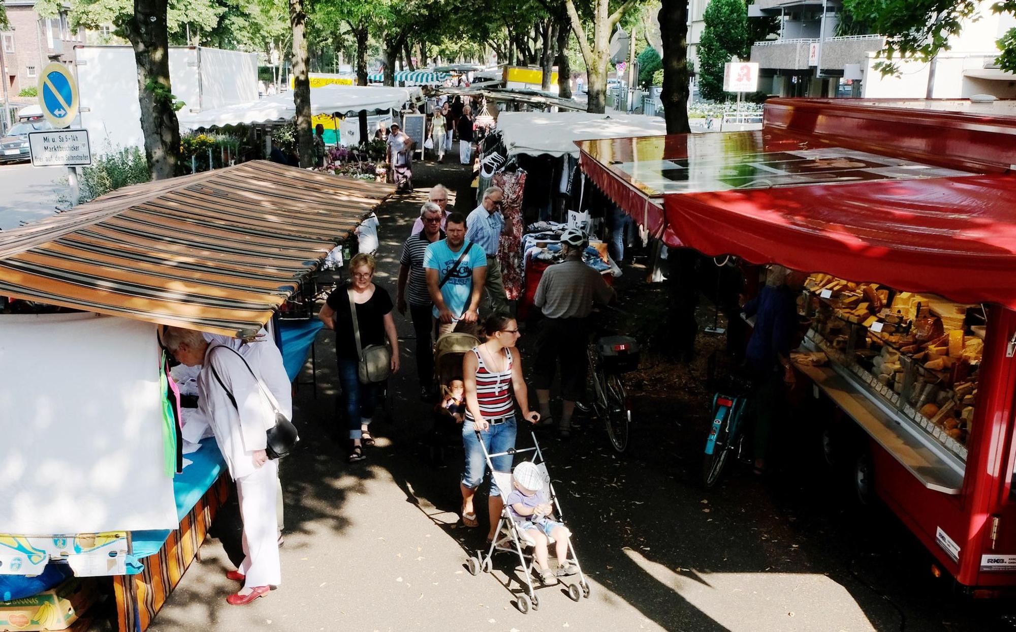 Menschen laufen auf einer Gasse zwischen Marktständen