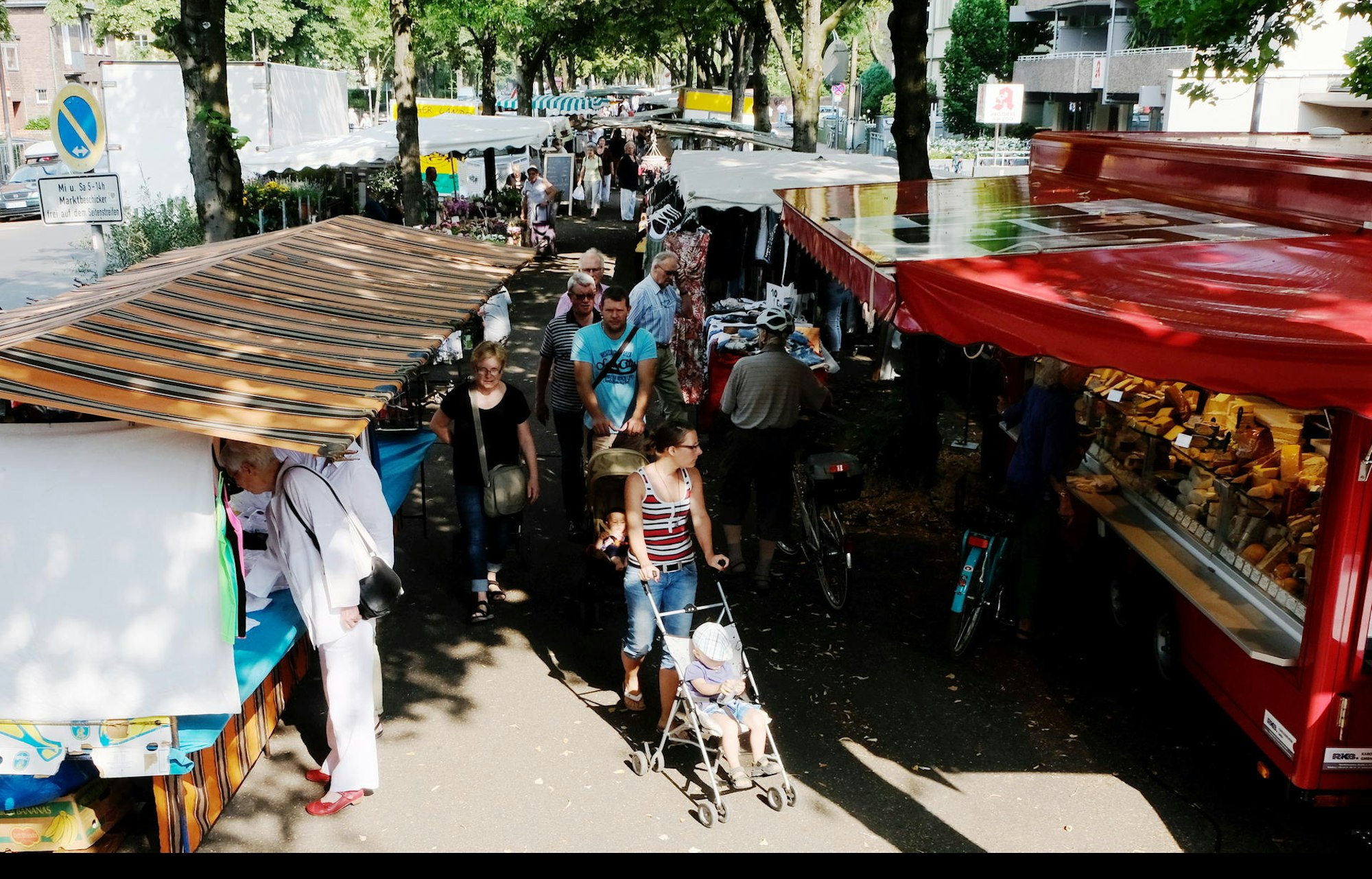Menschen laufen auf einer Gasse zwischen Marktständen