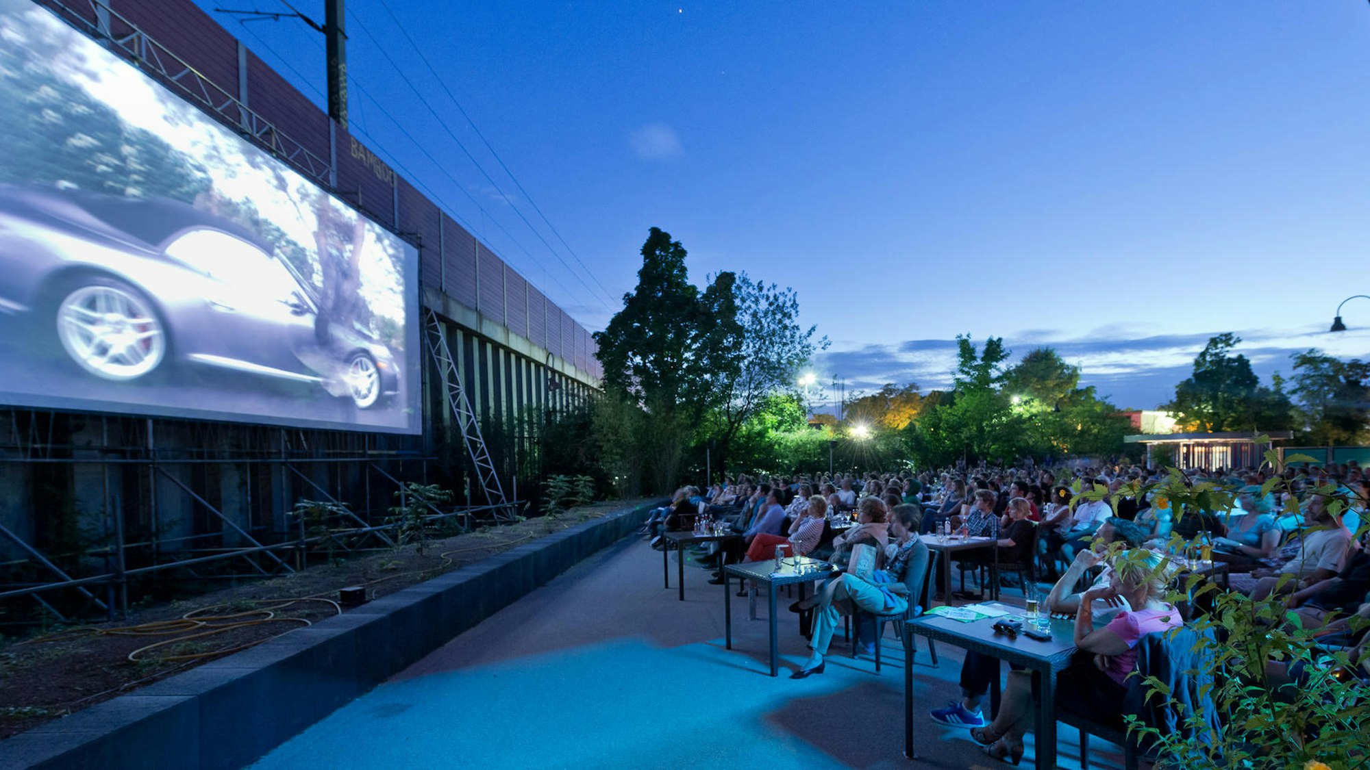 Menschen schauen einen Film im Hof des Cinenova Kinos.