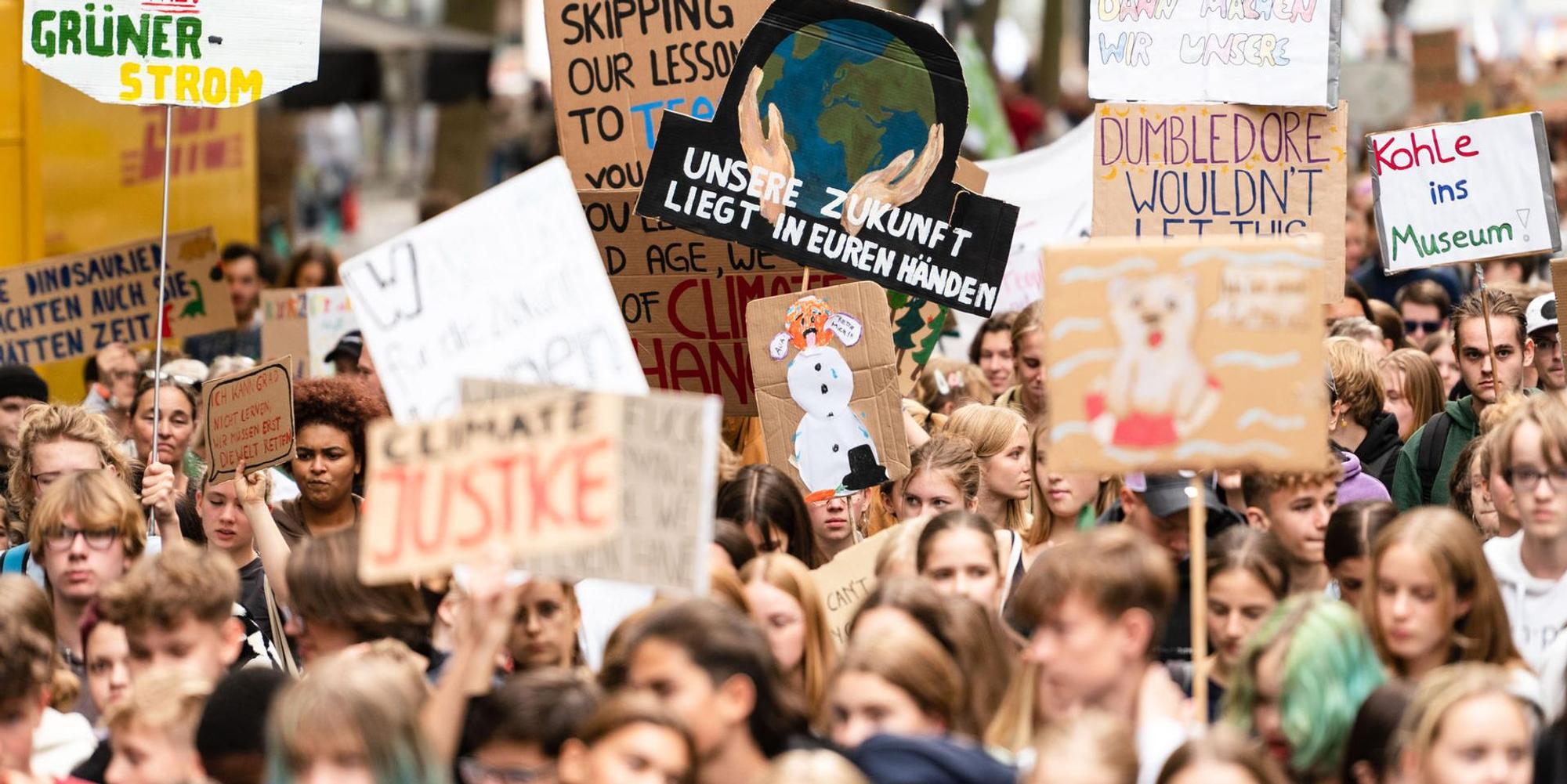 Junge Demonstrantinnen und Demonstranten ziehen im September mit Schildern zur Klimakrise durch Köln