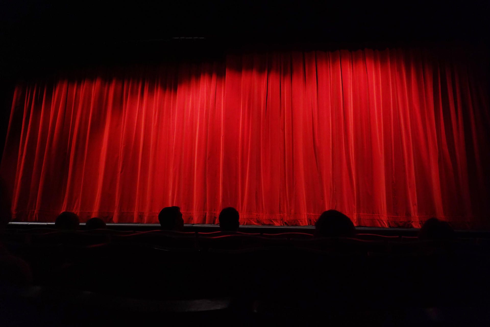 Ein roter Kinovorhang vor einer Leinwand.