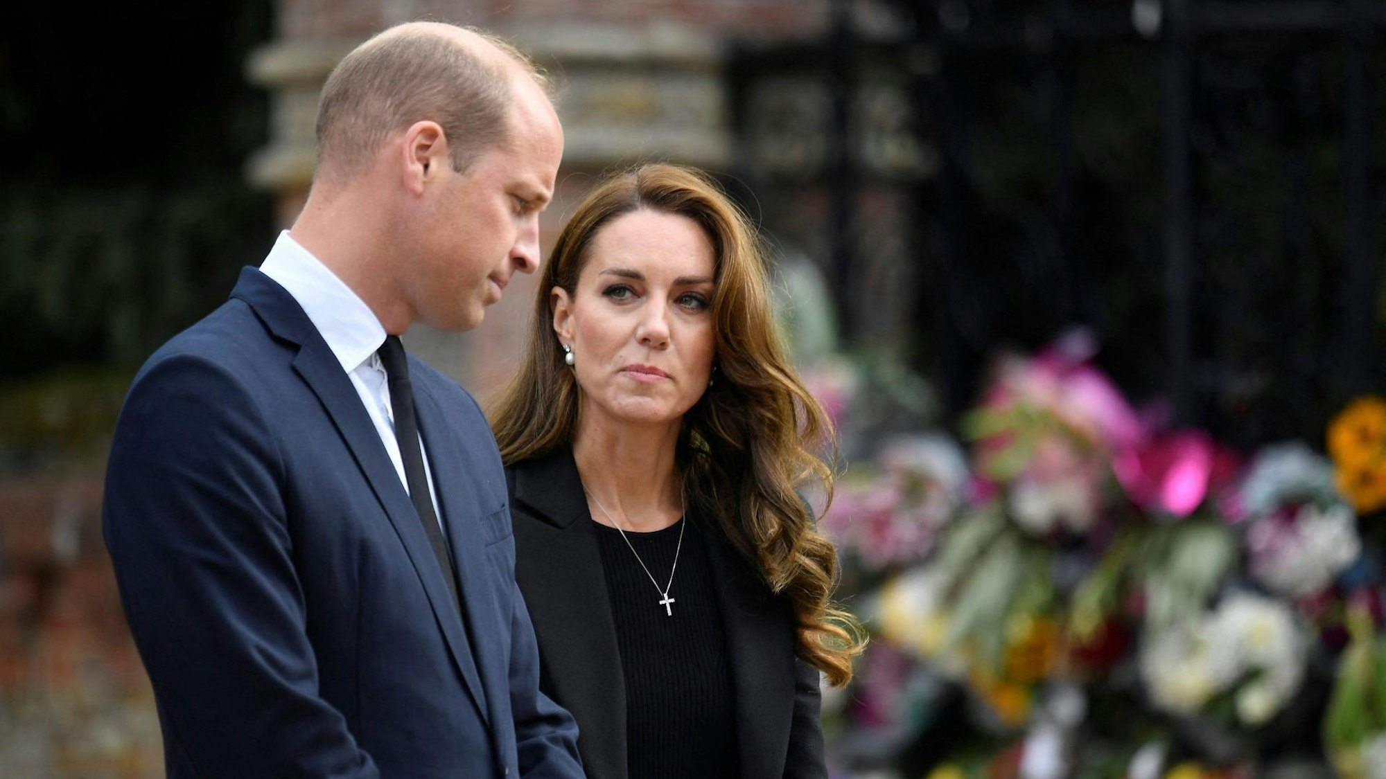Prinz William und Prinzessin Kate stehen vor einem Meer aus Blumen.