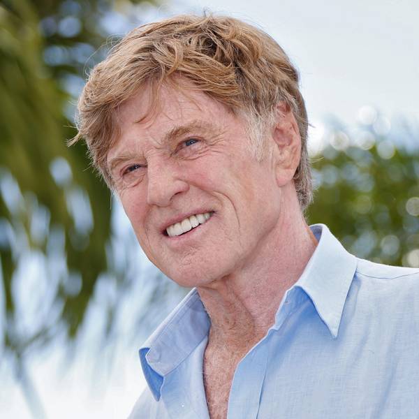 Robert Redford lacht für Fotografen.