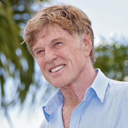Robert Redford lacht für Fotografen.
