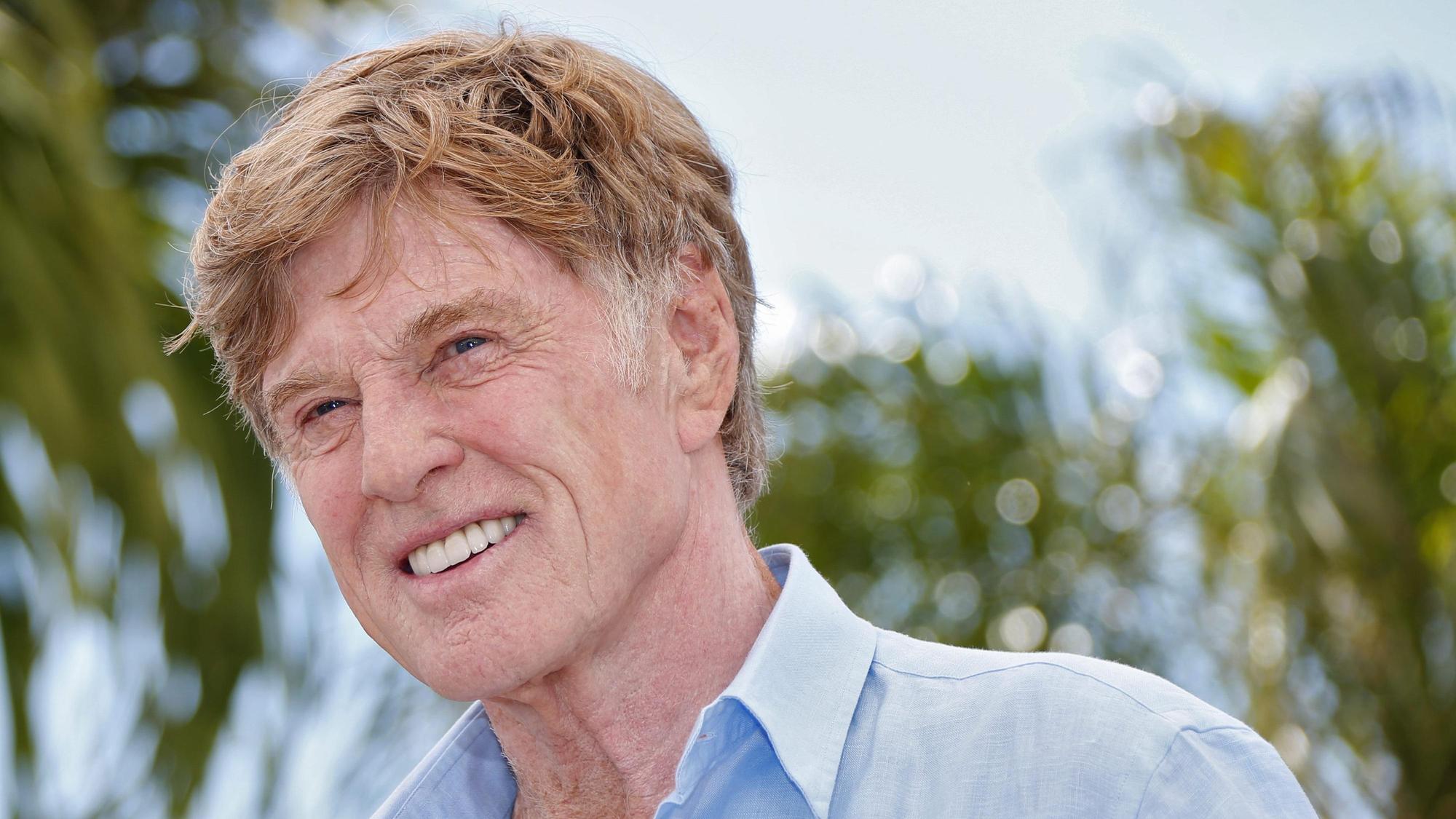 Robert Redford lacht für Fotografen.