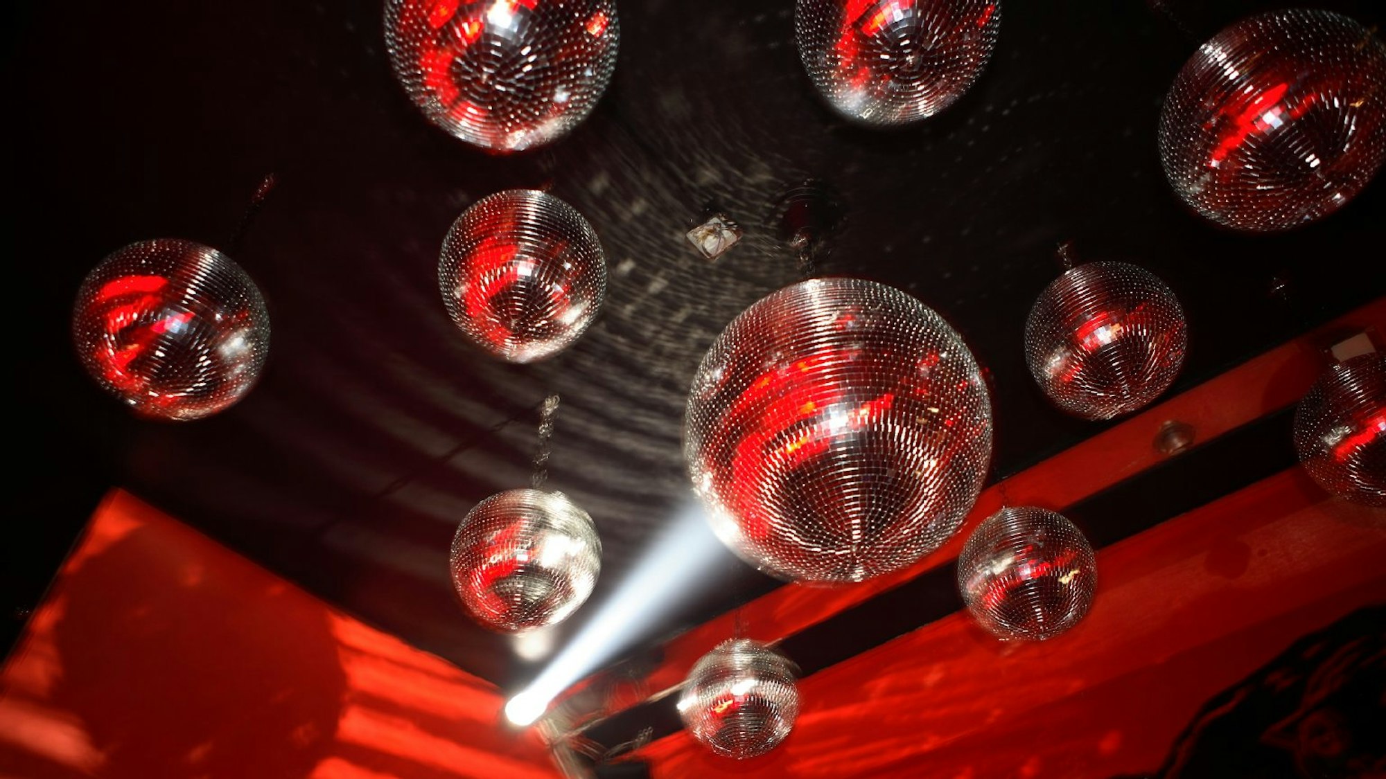 Diskokugeln werden in der Red Cat Lounge von Scheinwerfern angestrahlt.