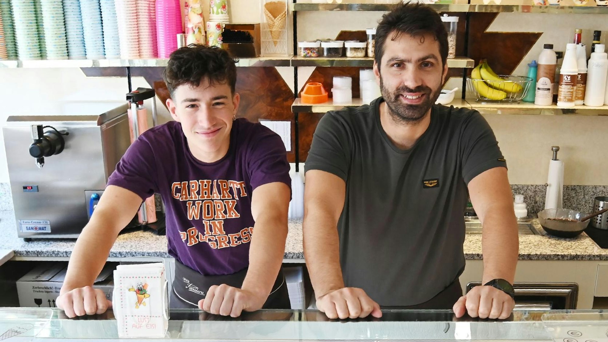 zwei Männer hinter der Theke einer Eisdiele