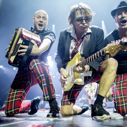 Kai Engel (l.), Harry Alfter und Peter Brings (r.) knien während eines Auftritts auf den Knien