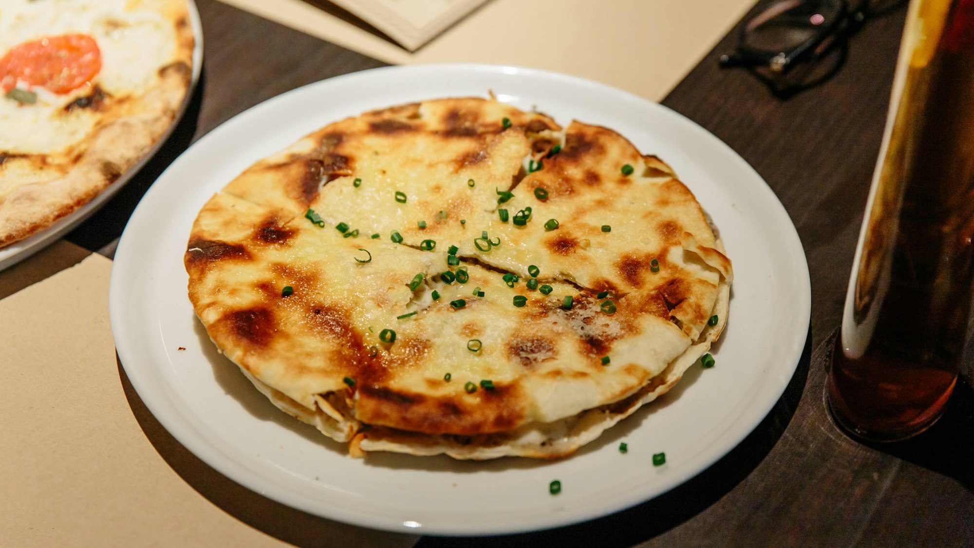 Puccia Brot ist mit Schnittlauch garniert auf einem Teller angerichtet