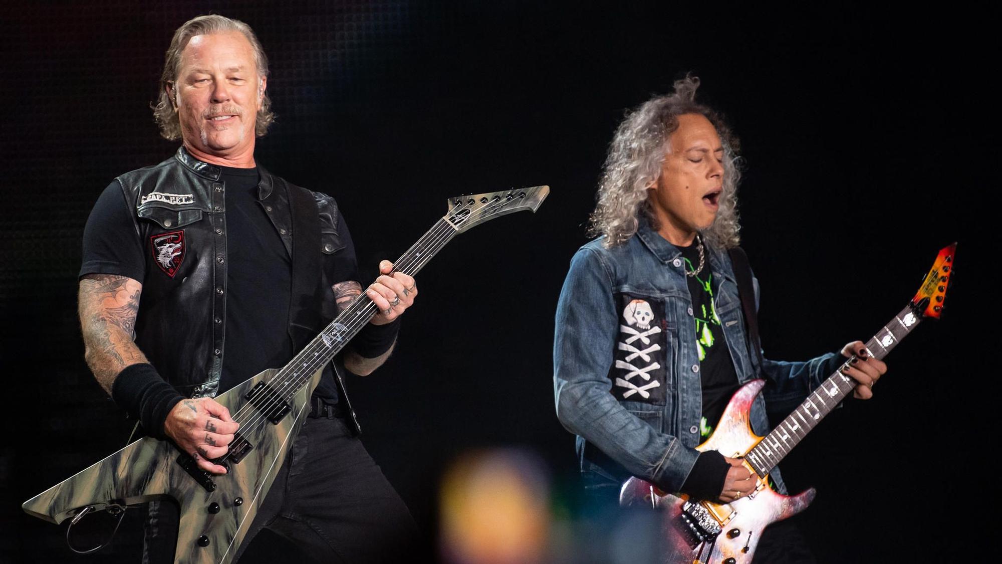 James Hetfield und Kirk Hammett von Metallica stehen auf der Bühne und spielen E-Gitarre.