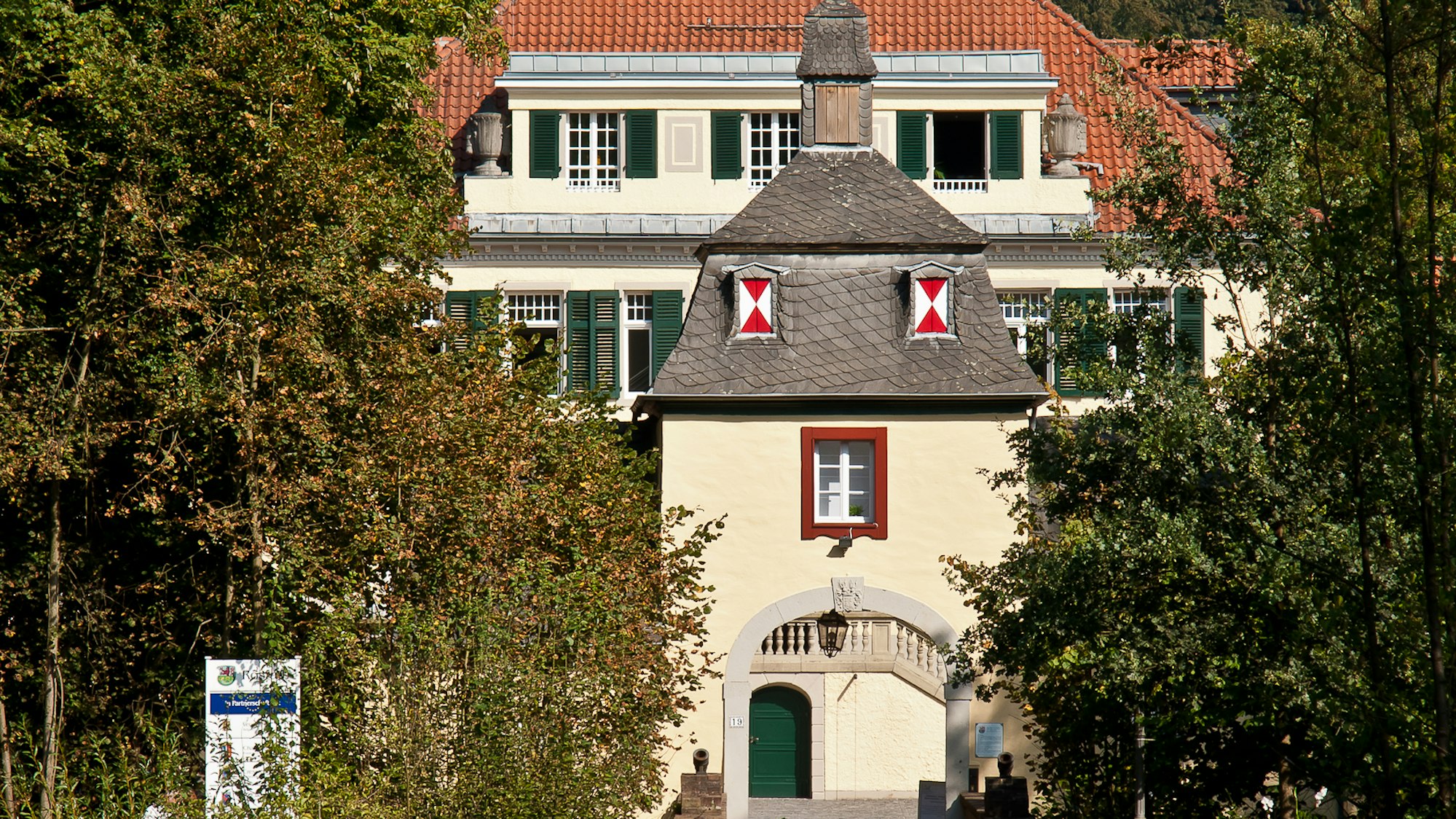 Haus Eulenbroich mit üppigen Bäumen und Sträuchen drumherum. (Archivbild)