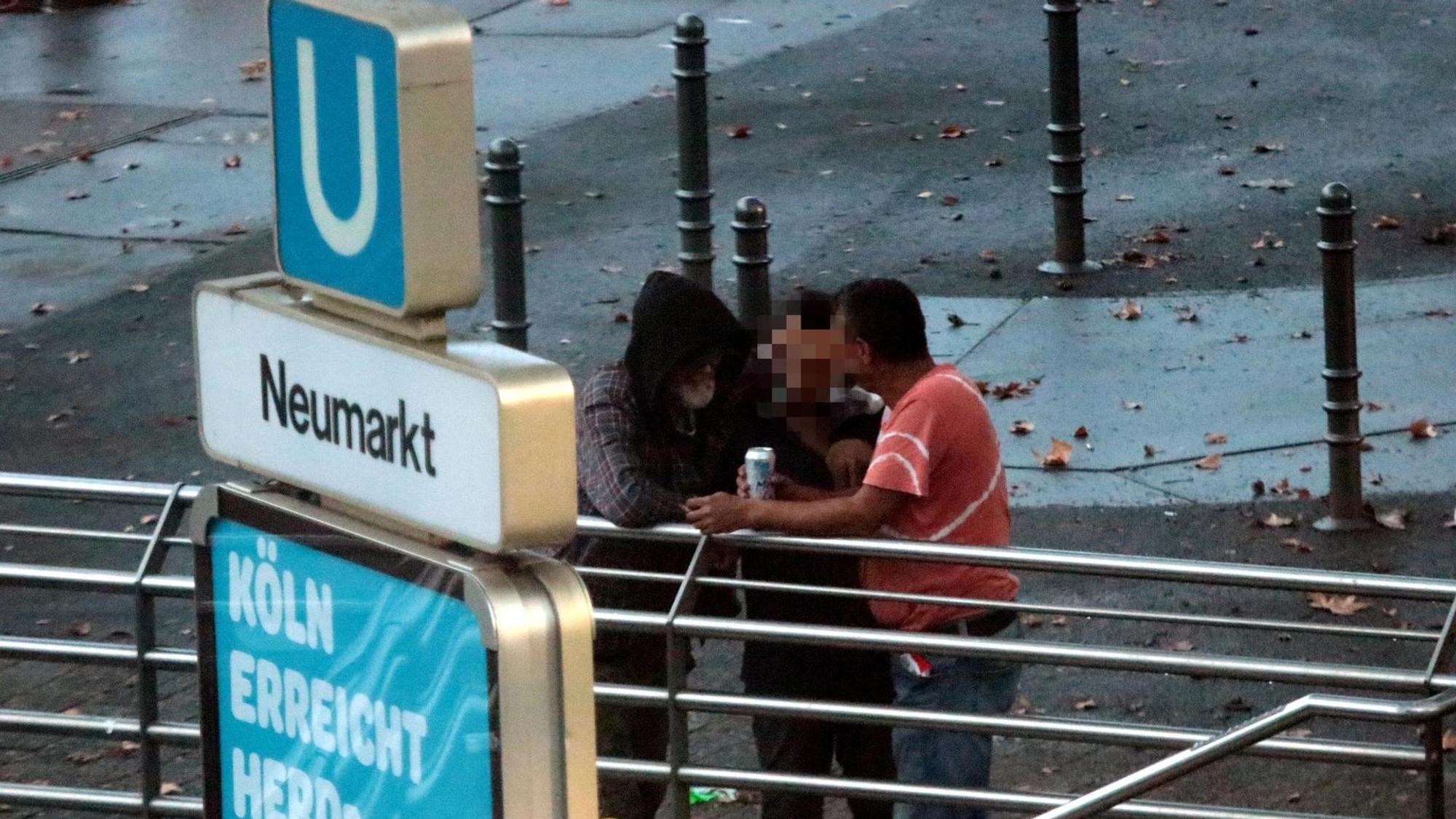Drei Männer stehen am Neumarkt zusammen, Drogen wechseln den Besitzer.