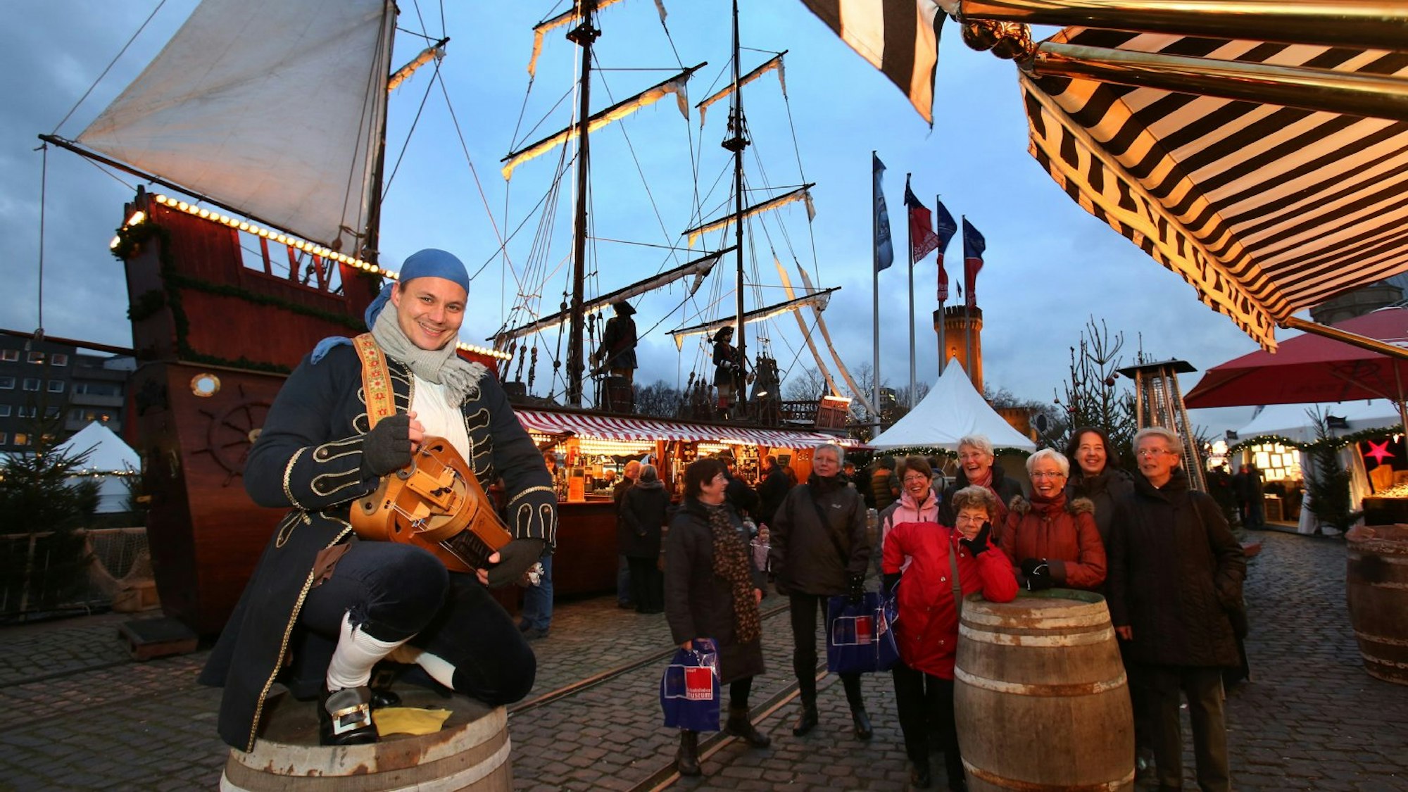 Besucher gehen durch den Weihnachtsmarkt vor dem Kölner Dom.