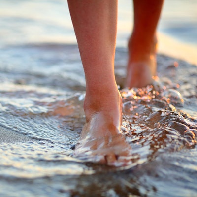 Frau geht barfuß im Wasser Getty Images
