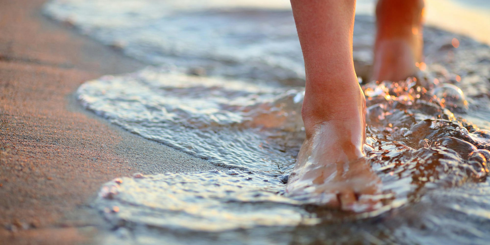 Frau geht barfuß im Wasser Getty Images